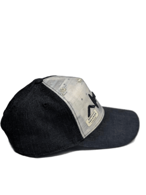 The Alpha Maui The Islander baseball cap features a black design with a gray front panel adorned with a rectangular beige patch that has black text. A small beige tag below reads "Aloha," and the side boasts an intricate map design. Ideal for your Hawaii beach apparel collection, the cap also includes a slightly curved brim.