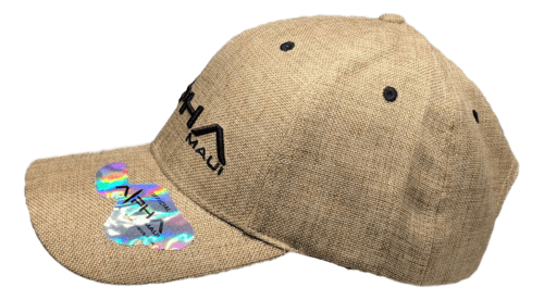 The Alpha Maui Regulator baseball cap boasts a textured beige finish and features the embroidered word "Maui" accompanied by a black mountain graphic on the front. Part of the exclusive Alpha Maui collection, this cap includes black ventilation eyelets and has a shiny, holographic sticker affixed to the brim.