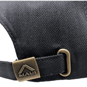 Close-up of a black fabric strap with a herringbone pattern, featuring a tarnished gold buckle and a rectangular gold clasp engraved with the word "Maui" and a triangle logo above the text. This piece, known as Charley Young - (Sunset), evokes the spirit of Hawaii, embodying the essence of Aloha and Ohana.