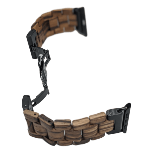 The Alpha Maui Band - Zebrawood 42mm (42-49mm) is showcased here with a woven design and black metal connectors. The partially open band reveals its clasp mechanisms and the intricate pattern of alternating wooden links. This accessory captures the essence of Hawaii, blending elegance with an island charm.