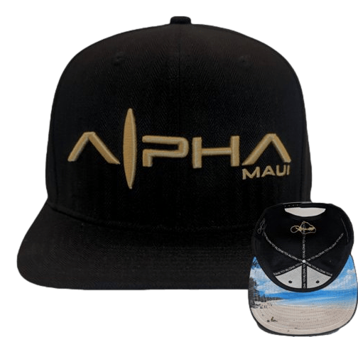 A black baseball cap named the Baldwin Beach Bro showcases the "Alpha Maui" logo on the front panel, which features a stylized surfboard design. Next to the cap is its underside, revealing a colorful beach scene complete with a lighthouse and a logo displaying crossed surfboards—making it an ideal piece of Aloha-inspired beach apparel.