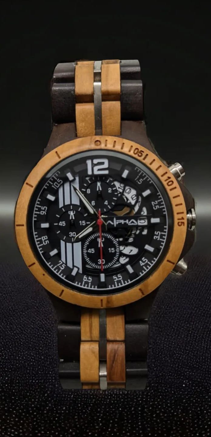 A stylish wristwatch, the Alpha Maui, features a two-tone wooden band with dark and light brown segments. The round face is black with a mix of large white Arabic numerals and intricate sub-dials, highlighted by a red second hand. This elegant accessory evokes the spirit of Hawaii and the warmth of Ohana.