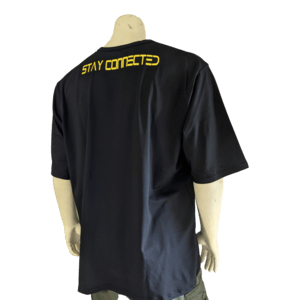 A person is shown from the back wearing "The Vibes," a dark navy blue T-shirt with the phrase "STAY CONNECTED" printed in bold yellow letters on the upper back. Embodying the spirit of Ohana, the individual is also dressed in green pants against a plain white background.