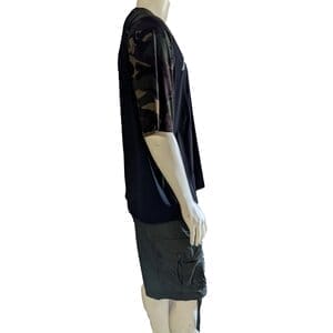 A mannequin wearing an Armor-1 black and camouflage-patterned short-sleeve shirt paired with gray cargo shorts, perfect for relaxed beach apparel. The mannequin is positioned sideways, showing the left profile. The white background highlights the clothing without distractions.