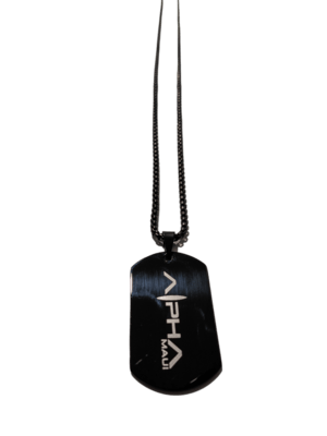 A black dog tag necklace, known as the "Alpha Tag", features the words "Alpha Maui" engraved in white letters. The pendant is suspended by a slender black chain, capturing the essence of Hawaii. The item is displayed against a simple white background.