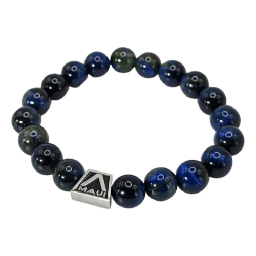 A beaded bracelet featuring dark blue beads with a glossy finish, strung on elastics. It includes a small square charm with the word "Maui" engraved on it. Simple and elegant, this Alpha Maui Band - Zebrawood 42mm (42-49mm) design is suitable for both casual and formal wear, making it perfect for beach apparel enthusiasts.