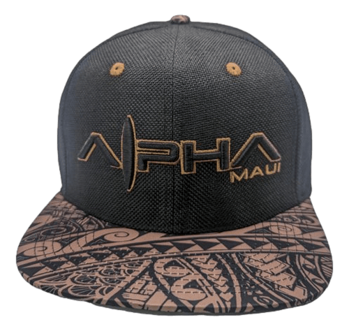 The Tribal Earth baseball cap features a black design with geometric and tribal patterns on the brim. The front panel has "Alpha Maui" embroidered in gold, capturing the spirit of Ohana and Aloha.