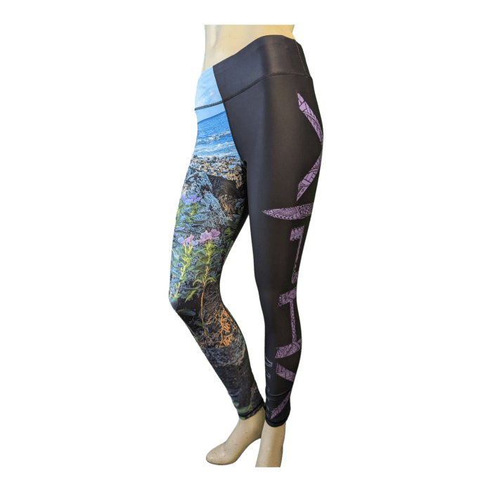 A mannequin showcases a pair of Alpha Maui La Perouse leggings, which feature a colorful scenic landscape on the left leg and solid black fabric with abstract purple patterns running down the right leg. The material appears to be stretchy and form-fitting, embodying an Alpha Maui aesthetic.