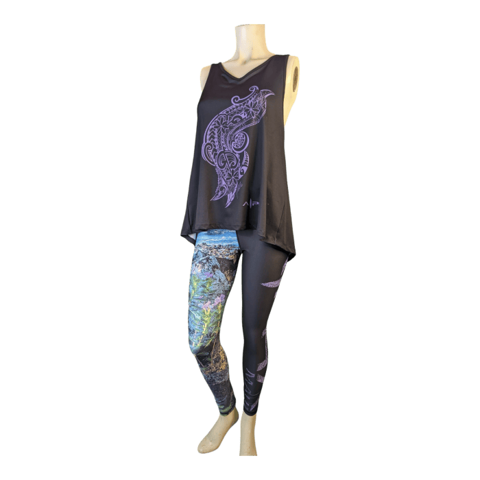 Mannequin displaying an outfit consisting of a black sleeveless top adorned with an intricate purple bird design, paired with the Alpha Maui La Perouse leggings: one leg featuring a multicolored nature scene inspired by Hawaii, and the other in solid black with subtle graphics.