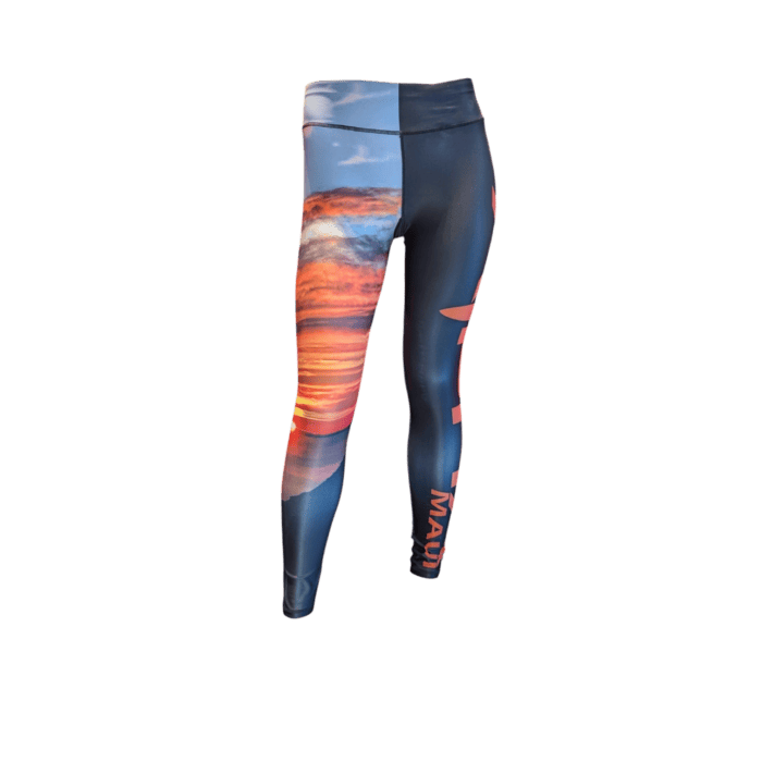 The Alpha Maui Haleakala full-length leggings feature a scenic sunset with orange and pink clouds over a dark landscape, highlighted by a vertical division and "MAUI" written in orange on one side.