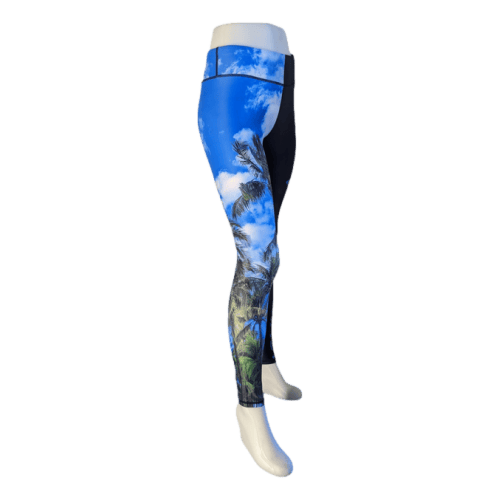 Side view of the Alpha Maui Hawaii (Full Length) leggings in blue and black, showcasing a tropical print of palm trees and clouds. These leggings make an excellent addition to any beach apparel collection. Displayed on a white mannequin from the waist down, the vibrant design exudes an unmistakable Aloha spirit.