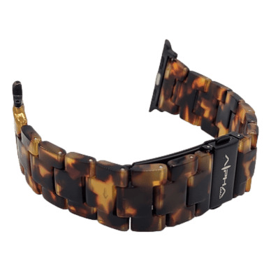 The Alpha Maui Band - Zebrawood 42mm (42-49mm) watch band features large, glossy links with a striking tortoiseshell pattern, perfectly complementing your beach apparel. This elegant accessory includes a black clasp engraved with the brand name "Alpha" along with a small triangle symbol beneath it. Ideal for adding a touch of sophistication to your Hawaii adventures or family (Ohana) gatherings.