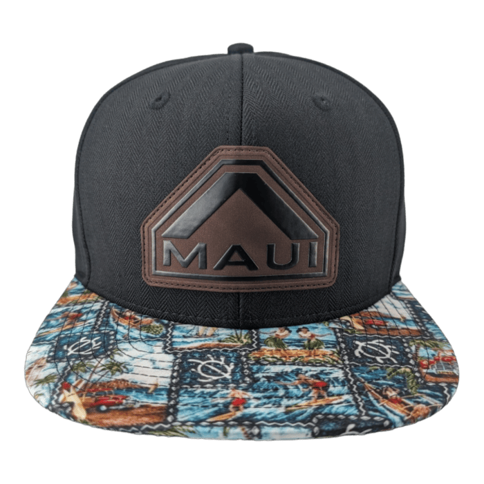 A black snapback cap with a geometric leather patch displaying the word "Maui" on the front. The brim features a colorful tropical print with scenes of surfing, palm trees, and sea life. The black background contrasts with the vibrant brim design, capturing the true essence of Aloha.