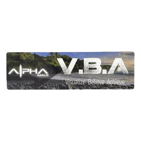 A promotional banner featuring the text "Let The Universe...Do Its Thing" on the left and "V.B.A" along with the slogan "Visualize Believe Achieve" on the right. The background image displays a rocky Hawaii beach with lush greenery and mountains in the distance, ideal for beach apparel enthusiasts.