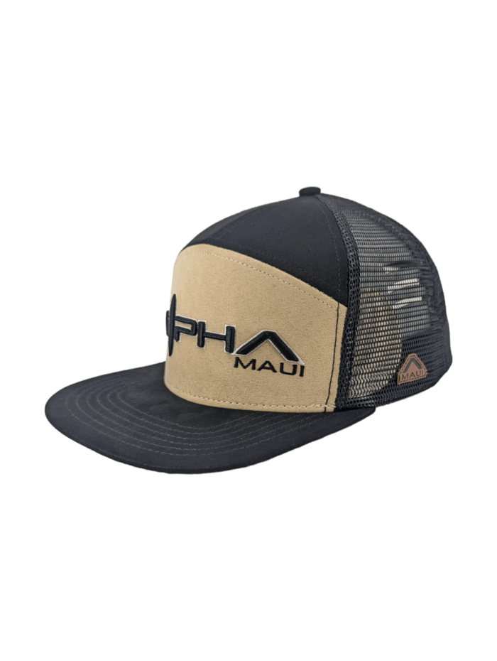 The Alpha Maui Kahmani hat features a beige front panel with "Alpha Maui" embroidered in black and gray text. The remainder of the hat is composed of black mesh, with an additional logo tag on the side—a perfect addition to your beach apparel.