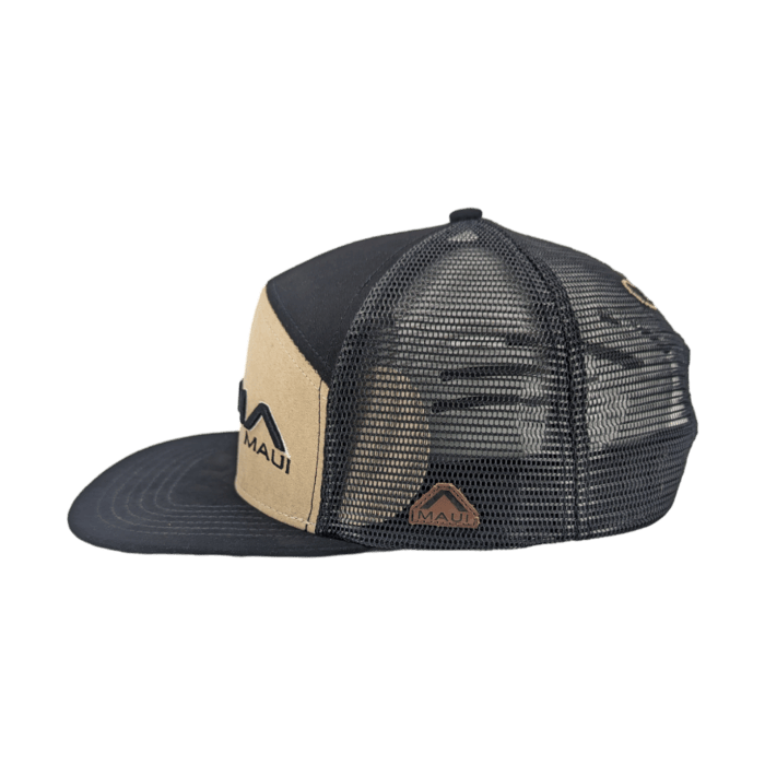 The Alpha Maui Kahmani is a black and tan trucker hat with "Aloha Maui" embroidered on the front panel. It features a mesh back for ventilation and an adjustable snapback closure. A small mountain logo adorns the front above the words "Aloha Maui.