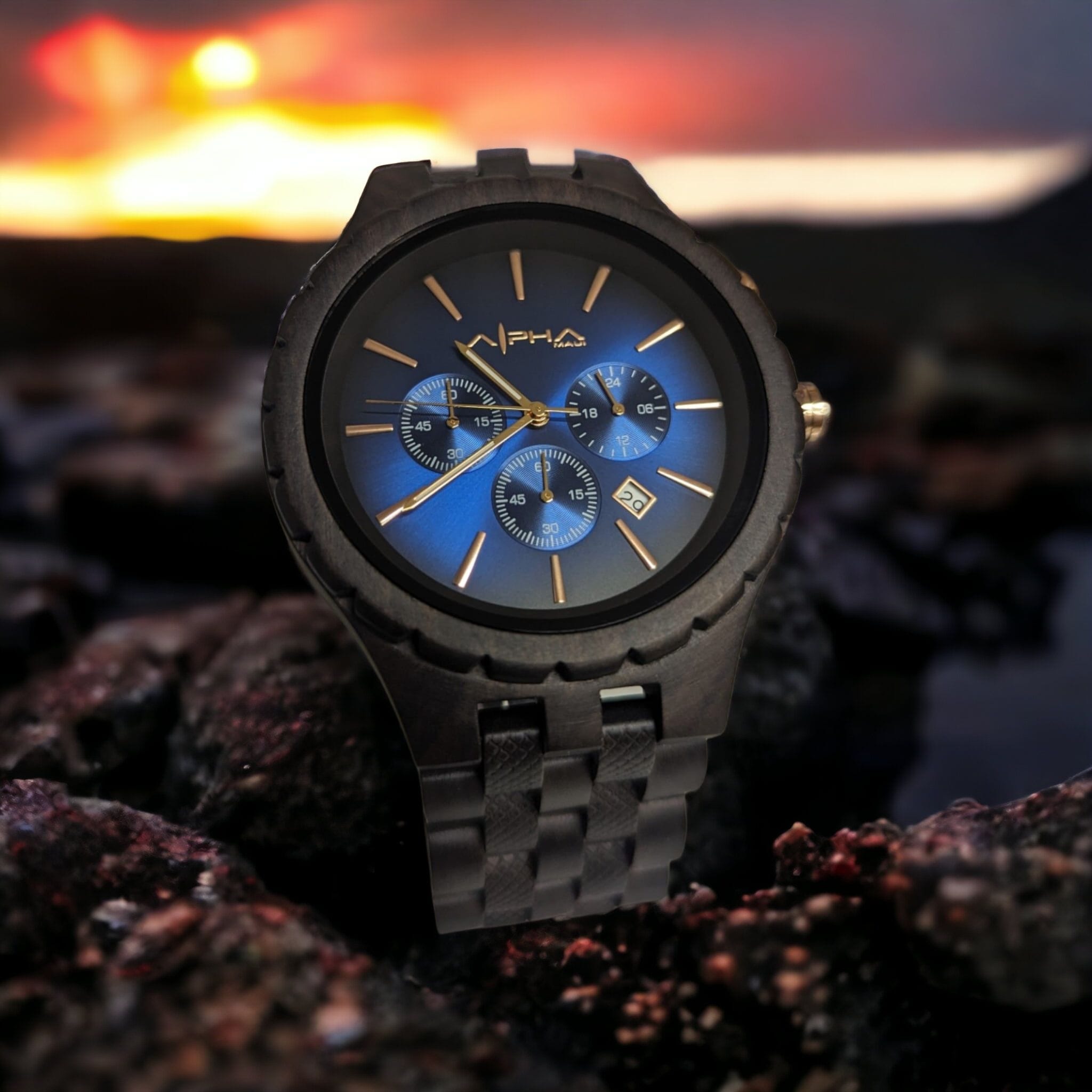 A sleek wristwatch with a dark metal band is displayed prominently against a blurred background of a vibrant Hawaiian sunset. The watch features a blue face with three smaller dials and gold hour markers, evoking the elegance of beach apparel. The brand "Alpha" is written on the watch face.