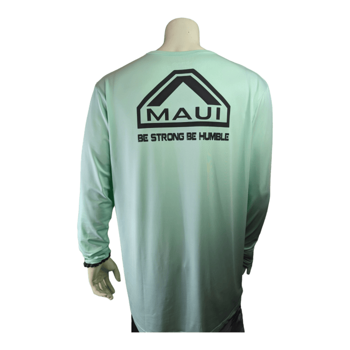 An image of a mannequin wearing a light green long-sleeve shirt. The back of the shirt features a black triangular logo with the words "Alpha Maui Big Daddy Cane" beneath it. Below the logo, there is a phrase that reads "BE STRONG BE HUMBLE." The mannequin's left hand rests by its side.