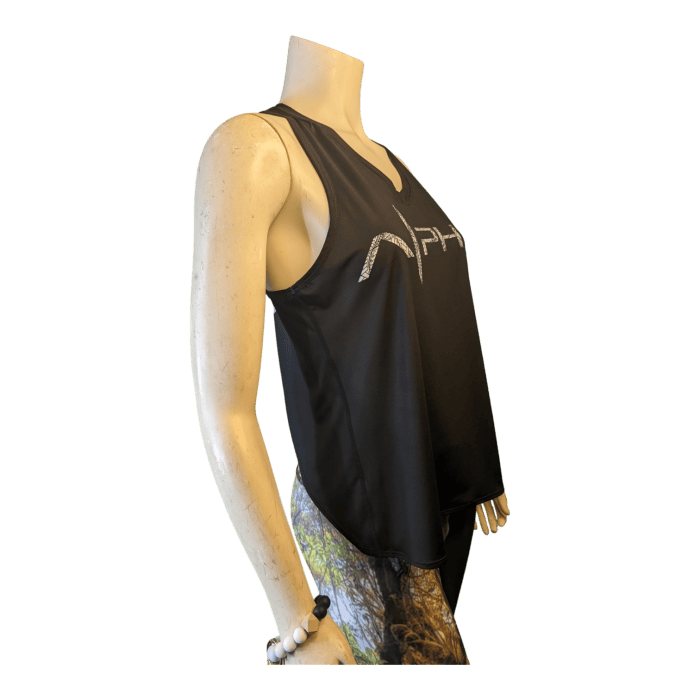 Side view of a mannequin wearing the sleeveless black Alpha Maui U'i Tank with a reflective Alpha Maui logo, paired with colorful leggings. The mannequin's left wrist is adorned with a white bracelet.