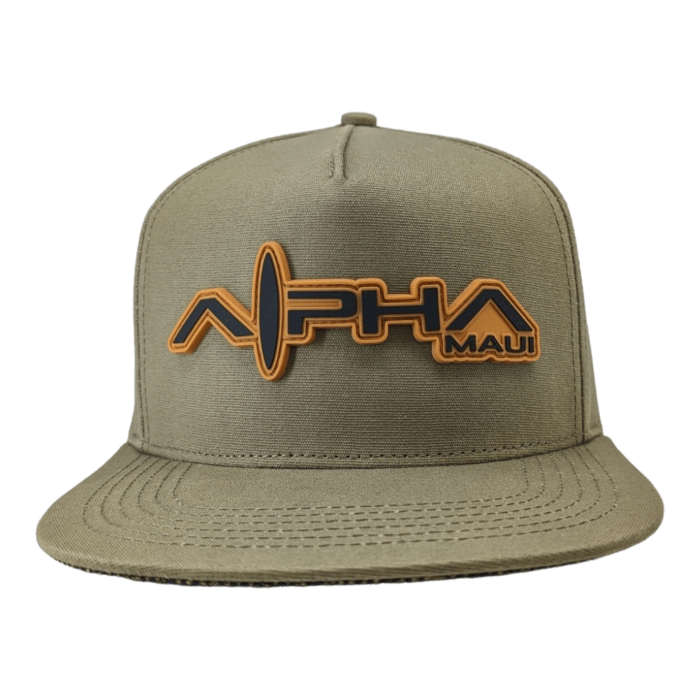 The Alpha Maui Coalition Forces snapback hat in khaki-green features a large embroidered logo on the front, showcasing "Alpha Maui" in a stylized font with an oval shape behind it and "Hawaii" in smaller text to the right. The hat has a flat brim and a structured front panel.