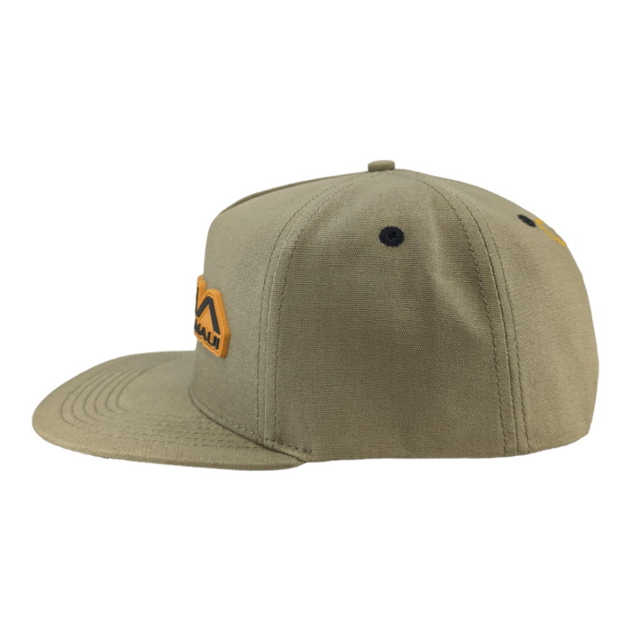 A side view showcases the Alpha Maui Coalition Forces snapback cap, which features a flat brim and beige color. The cap is accented with black ventilation eyelets and boasts a yellow and black triangular logo patch on the front left panel, making it a perfect addition to your Alpha Maui beach apparel collection.