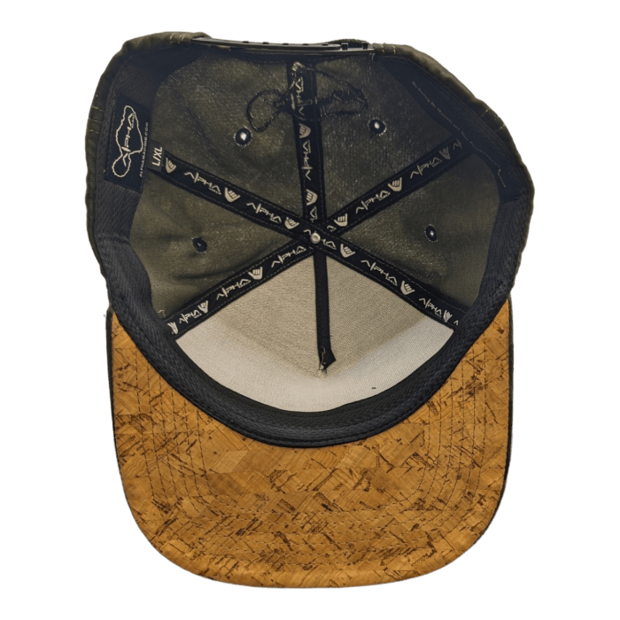 This is an image of the inside view of the Alpha Maui Coalition Forces baseball cap. The bill, crafted from a cork-like material, complements the black fabric straps adorned with unique logos. The inside fabric features a blend of dark and light colors, epitomizing stylish beach apparel.