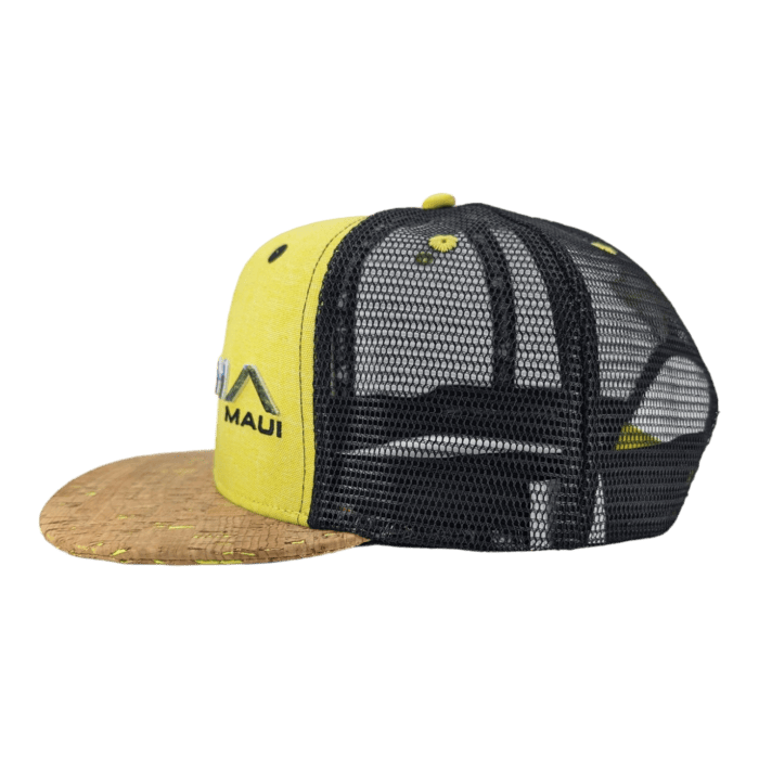 The Alpha Maui The Valley Isle is a yellow and black mesh baseball cap with a cork brim. It features "Maui" embroidered on the side and a front floral pattern visible through the mesh. Perfect for beach apparel, this cap includes an adjustable snap at the back.