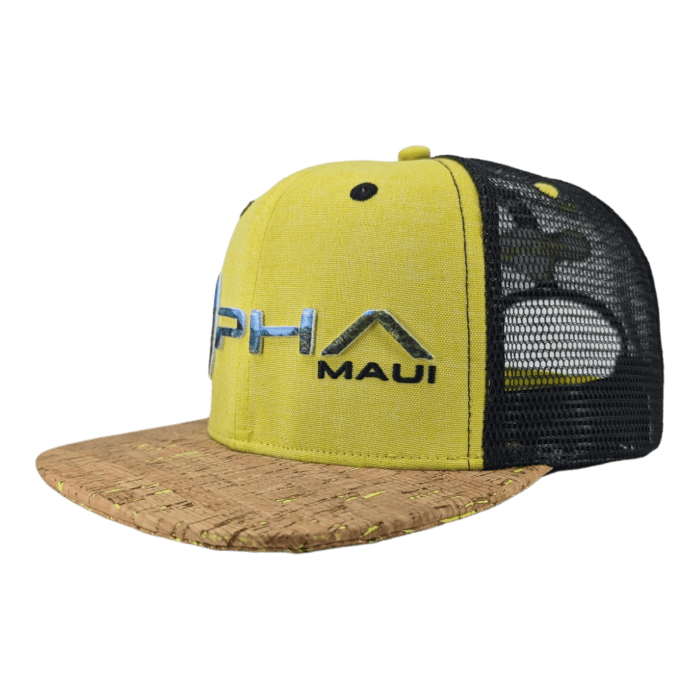 Introducing the Alpha Maui The Valley Isle – a yellow and black trucker hat with a cork brim, ideal for beachwear. The front panel showcases "Alpha Maui" text accompanied by an embroidered logo. With black mesh sides and a snapback closure for an adjustable fit, this hat brings Ohana vibes and a touch of Hawaii to your style.