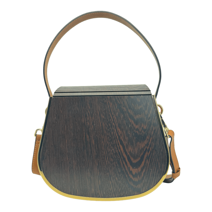 The Alpha Maui Rockit Carrier Purse showcases a unique design with a dark wood-like finish on its rectangular body, accented by gold along the edges. It features a single brown leather strap on top and an adjustable leather shoulder strap connected with gold hardware, making it perfect for your beach apparel.