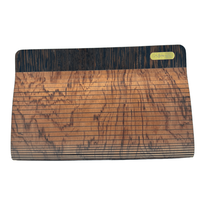 The Alpha Maui The Clutch Carrier is a beautifully crafted wooden board with a smooth, polished surface that showcases a distinctive pattern of horizontal lines and natural wood grain. The top section features a darker hue and includes a small rectangular plaque with the Alpha Maui logo and some text, embodying the spirit of Aloha commonly seen in beach apparel.