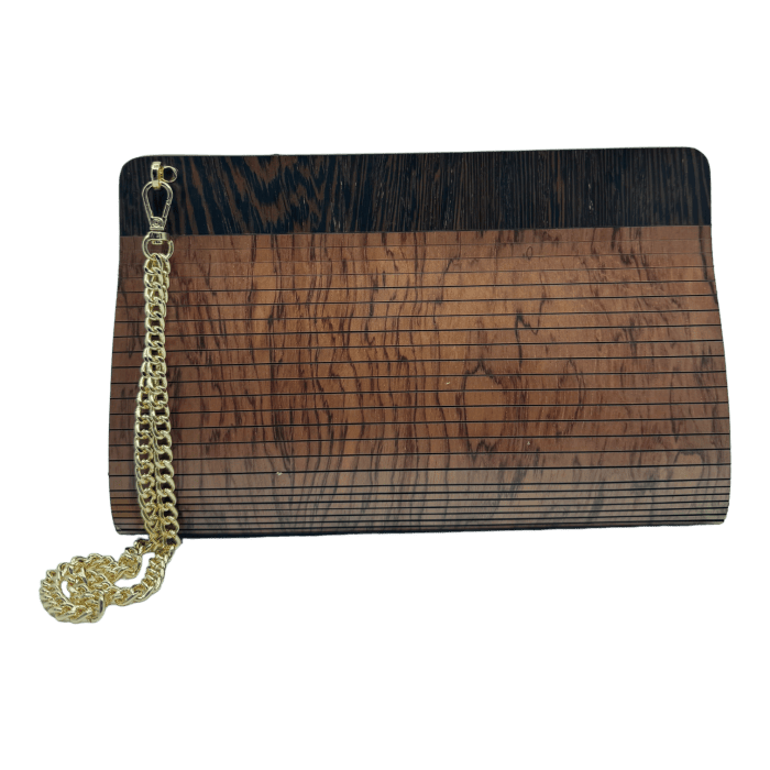 Introducing the Alpha Maui The Clutch Carrier, a rectangular clutch bag with a sleek wood grain design in varying shades of brown. Perfect for complementing your beach apparel, this bag features horizontal lines, a polished finish, and a gold chain strap attached to one corner. The background is plain black.