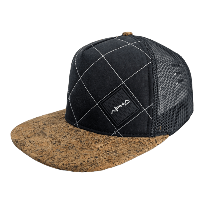 A black mesh trucker cap with a brown cork visor and decorative white stitching on the front panel. The front also features a small black patch with white text that reads "APHIA." This cap adds an Ohana touch, perfect for bringing a little Aloha spirit from Hawaii into your everyday wear.