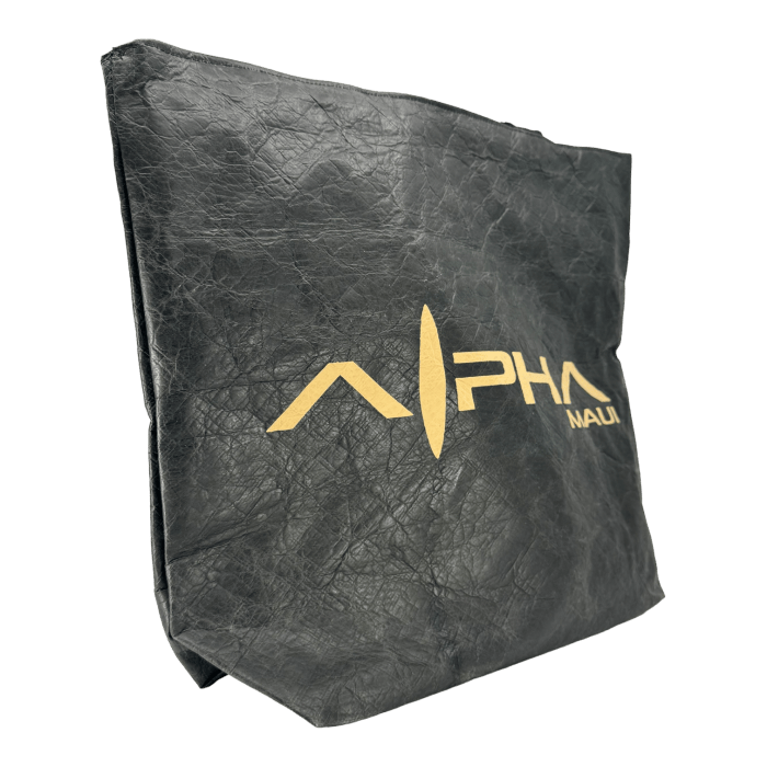 A close-up image of the Alpha Maui Dupont Bag, made of black leather and slightly crumpled. The front prominently features the "Alpha Maui" logo in gold lettering, designed with a stylized abstract arrow pointing upward between "Alpha" and "Maui." The background is black.