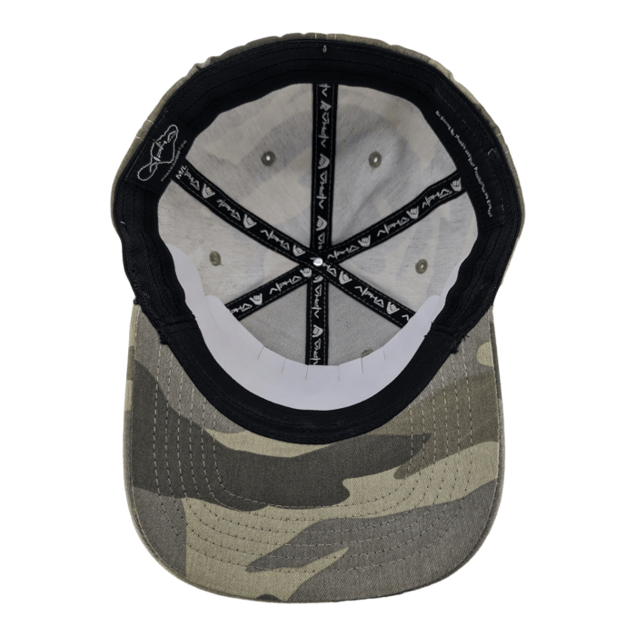 A camouflage-patterned baseball cap is shown from the underside, revealing a black sweatband and a gray interior. The interior stitching forms a star shape, with the brand "Vland" repeated on the inner bands. A small Alpha Maui logo is visible near the seam.