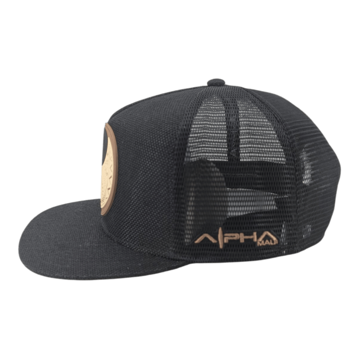 The Alpha Maui The Balance is a black mesh trucker hat with a flat brim, featuring a round beige front patch and "APH MALI" in gold on the mesh side.