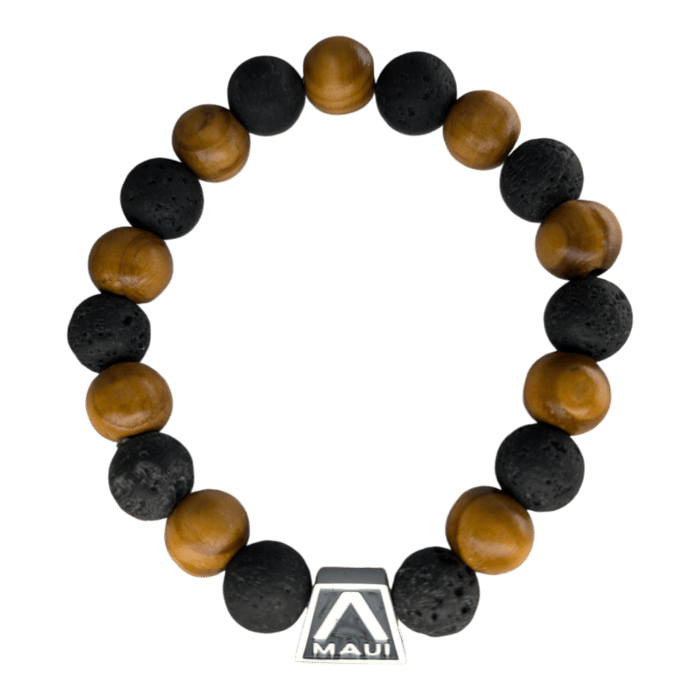 Introducing the Shell Pearlet, a beaded bracelet designed with alternating brown wooden beads and black lava rock beads. This exquisite piece features a silver decorative element adorned with the word "Maui" and a triangular logo, making it an ideal accessory to elevate your Alpha Maui beach apparel. The bracelet is showcased against a sleek black background for a stunning visual appeal.