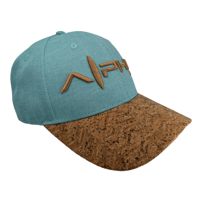 The Turtle Cove II is a teal baseball cap featuring a natural brown cork brim. It showcases a stylized logo with the text "APH" embroidered in a matching brown color on the front.