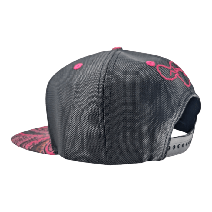 The Tribal Wai is a black snapback hat adorned with a colorful, intricate design on the underside of its flat brim. It features pink eyelets and stitching, along with an embellished pink graphic on one side. The adjustable strap at the back is also visible.