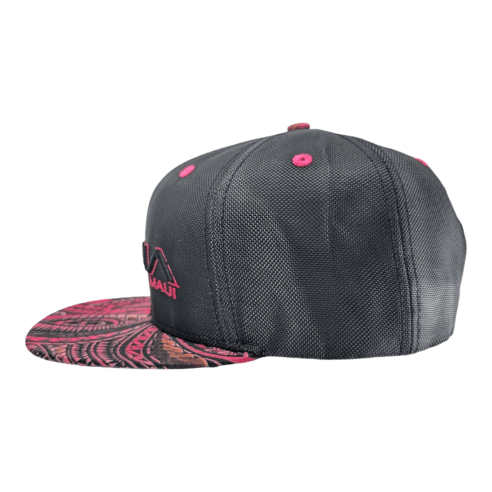 The Tribal Wai snapback hat is black with pink accents on the ventilation eyelets and brim, which includes an intricate pink and black pattern. The side of the hat features an embroidered pink logo along with the word "HAWAII.