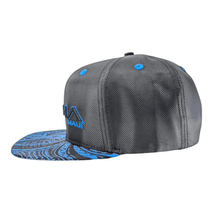 The Tribal Wai snapback hat is black with blue embroidered lettering and designs. The front features the text "Maui" and a stylized wave graphic, while the flat brim showcases intricate blue patterns. Blue eyelets are included for ventilation.