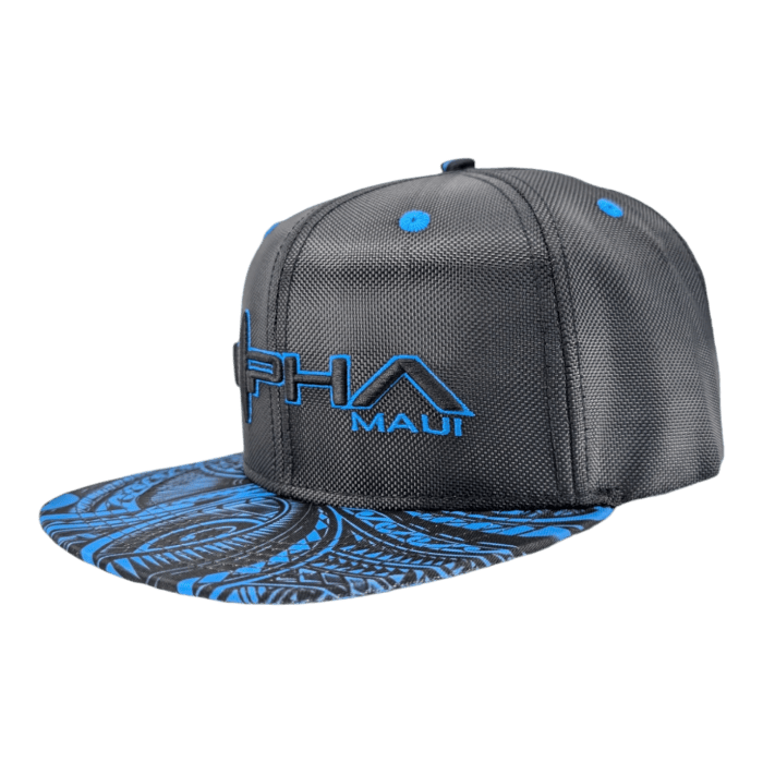 The Tribal Wai snapback hat is a dark grey cap with blue accents, featuring the "PHA MAUT" logo embroidered in blue on the front. The bill showcases an intricate blue and black abstract pattern, while the top is adorned with blue stitching and button details.