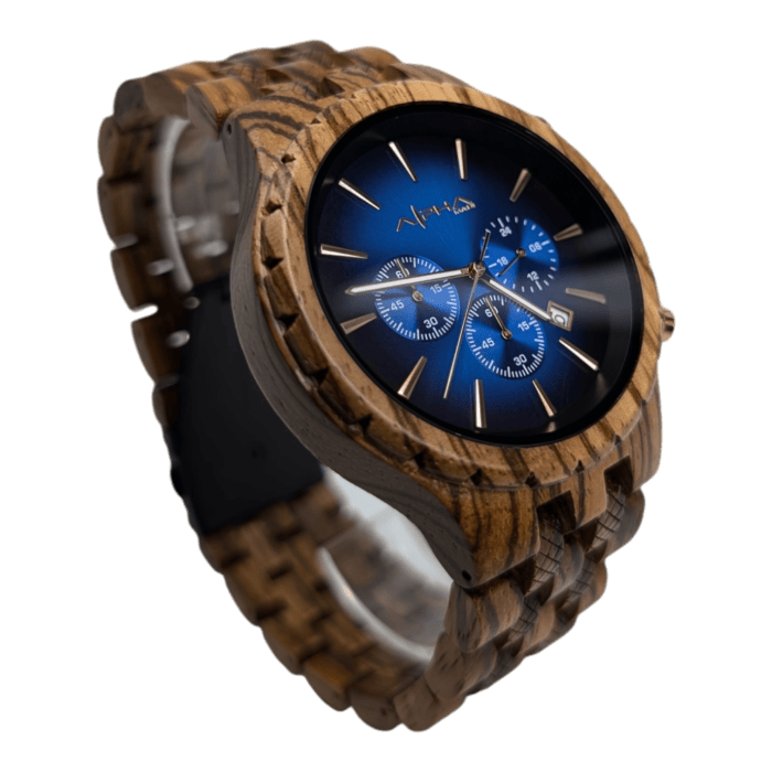 The Voyger is a wooden wristwatch with a blue dial featuring three subdials and a silver date display. It has thin, silver hour markers and hands, while the wooden strap showcases a natural grain pattern. The brand name is prominently visible on the watch face.