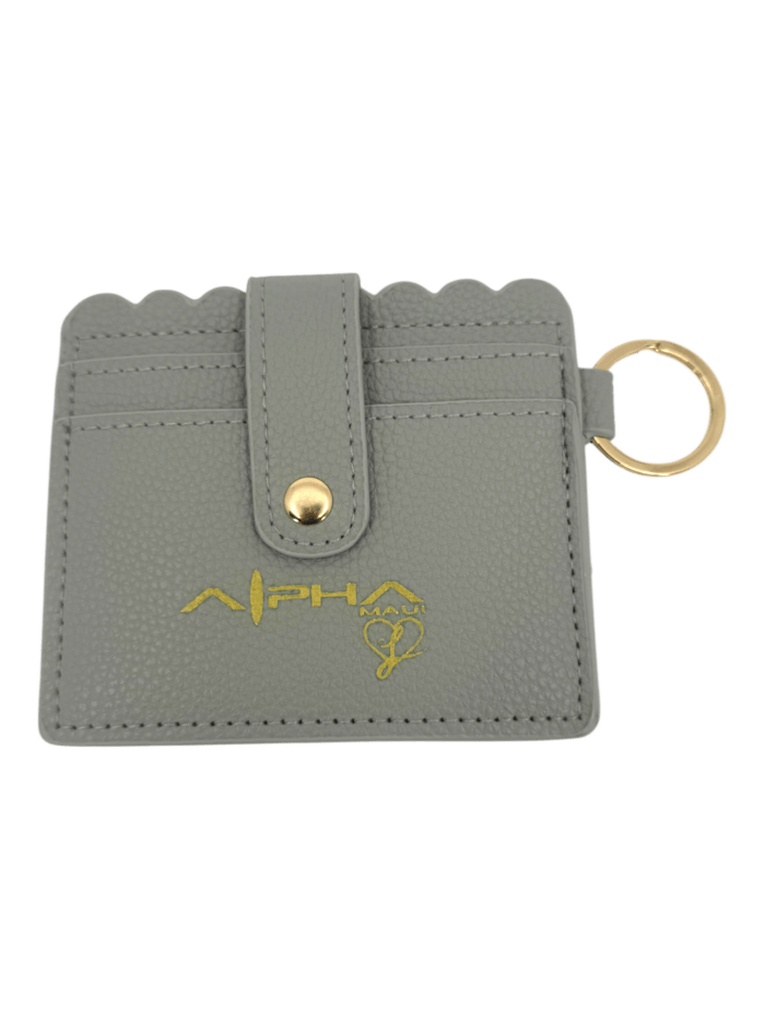 A gray textured cardholder with a scalloped edge, gold snap button, keyring, and gold "ALPHA" logo with a paw print design on the front.