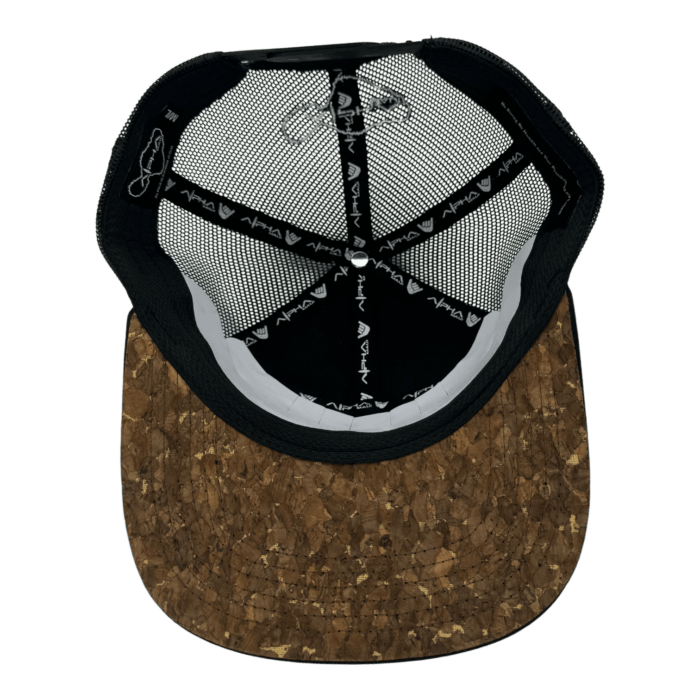 A top view of a baseball cap with a unique design. The outside features a textured cork visor, while the inside shows a black lining with white logos and mesh panels, providing breathability and style.